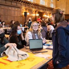 Student approaching a club table at the Winter Frolic in Great Hall 